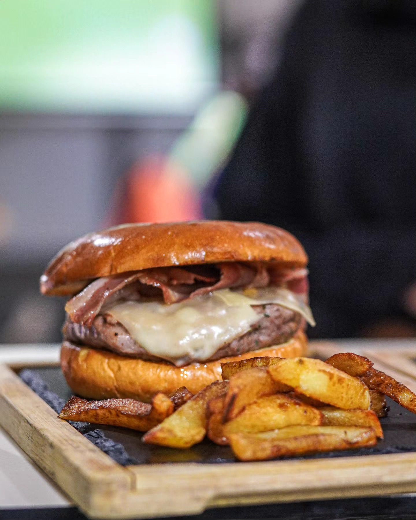 Hamburguesa amb formatge fos i patates, sobre una fusta
