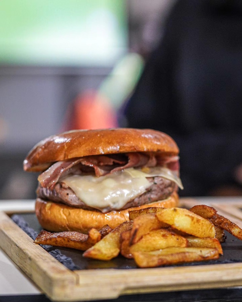 Hamburguesa amb formatge fos i patates, sobre una fusta
