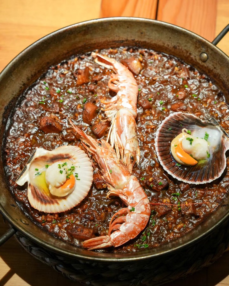 Arròs a la paella amb un escamarlà i dues petxines, vist des de dalt