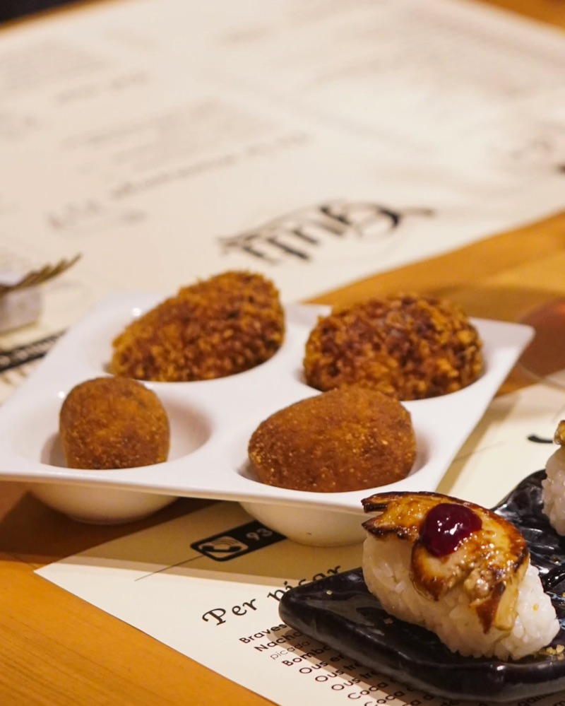 Croquetes i un nigiri de foie sobre les estovalles del Guti