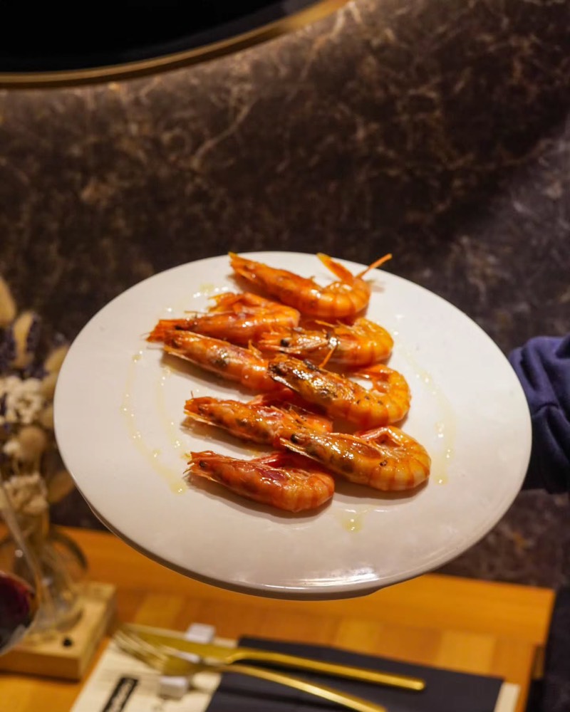 Un plat de gambes a la planxa sobre la taula parada